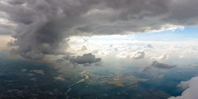 Gewitterwolken in Luftbild mit Blick auf Gelände